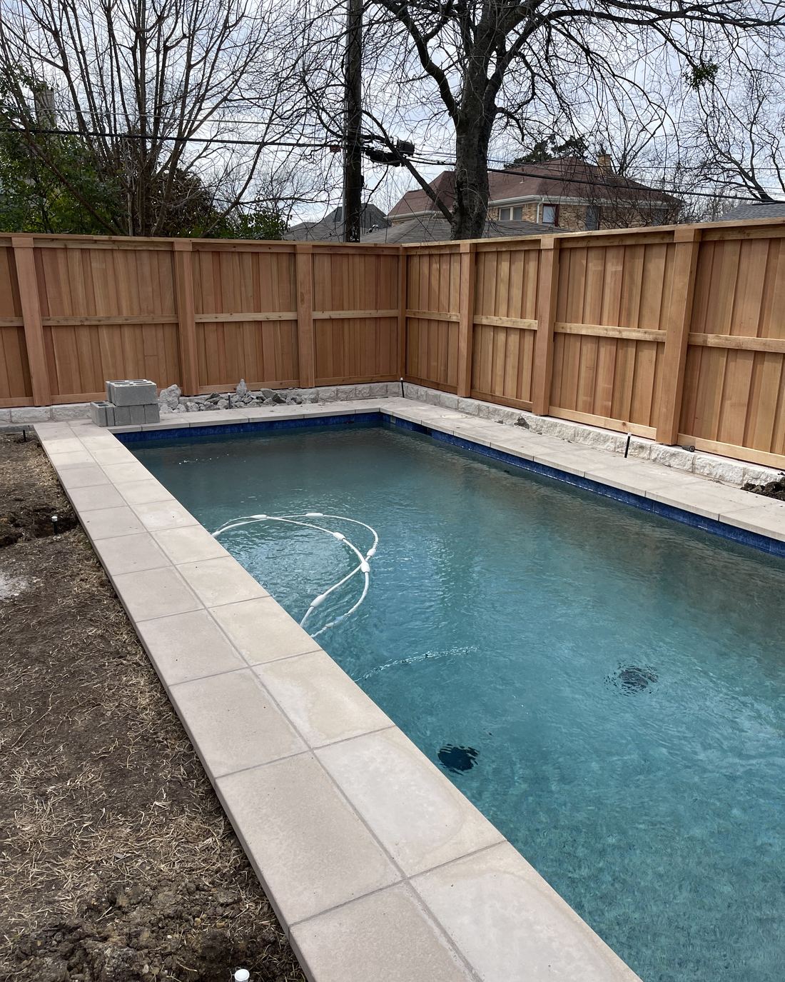 A finished cedar privacy fence around a new back-yard pool