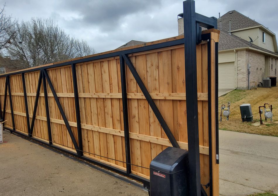 A steel-framed cedar cantilever slide gate seen full length, with its opener mounted at the post
