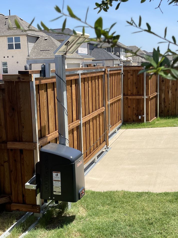 A stained cedar slide gate on its track with the gate opener mounted beside it