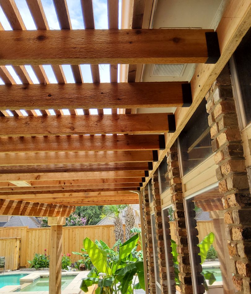 Cedar rafters and a slat privacy screen over a poolside patio
