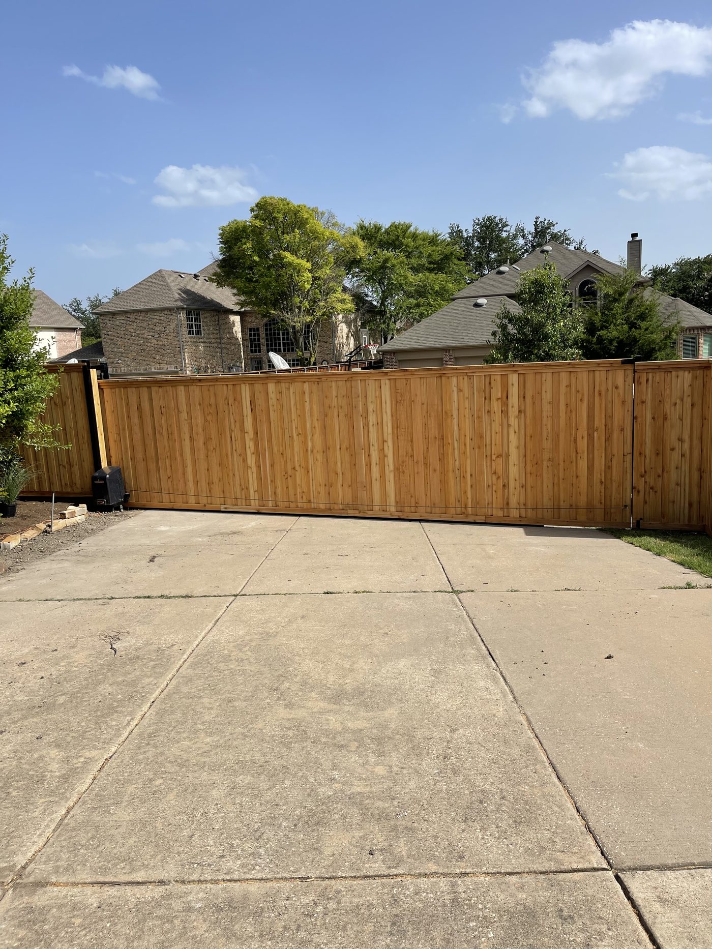 A full-width cedar sliding driveway gate built by Future Fence, closed across a North Dallas driveway