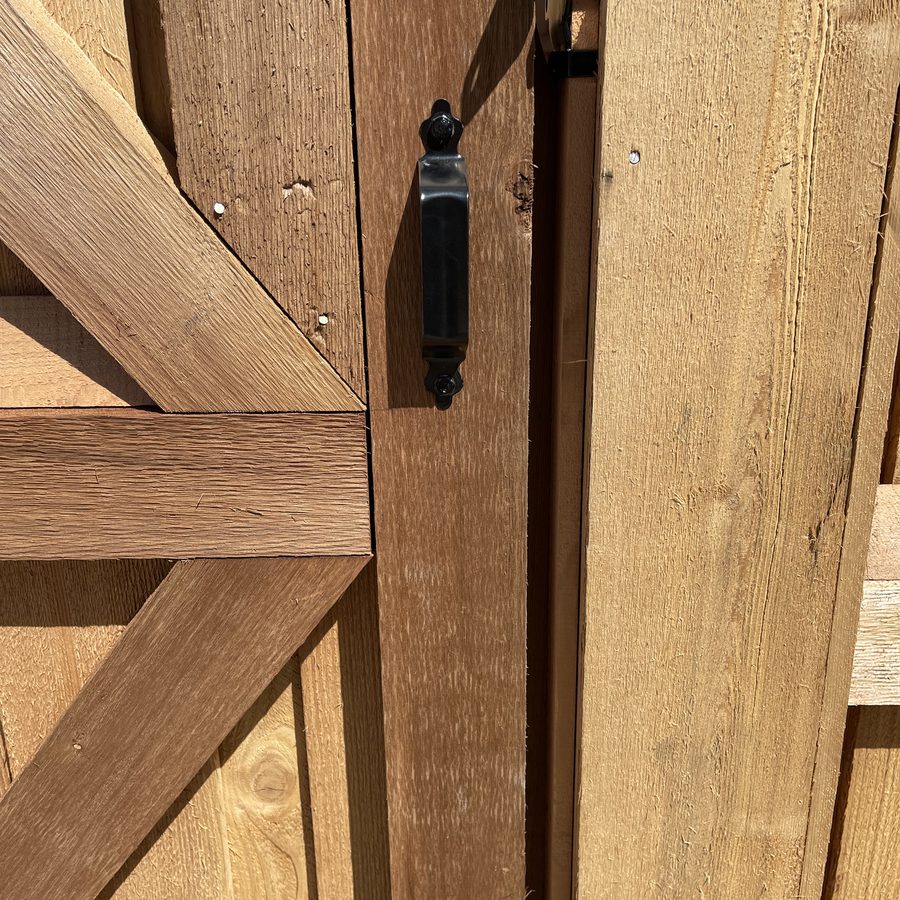 Close-up of black gate hardware and cross-brace joinery on a cedar gate built by Future Fence